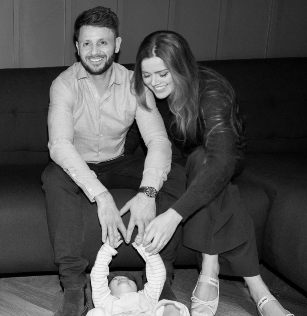 Black and white photograph of a family sitting together on a sofa